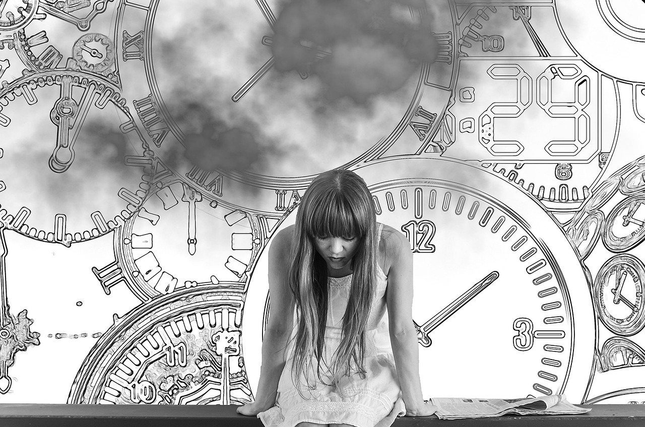 girl with hands on table, time clocks behind her in black and white photo