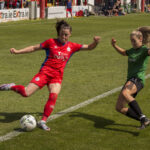 Cristie Gray, red Shelbourne FC uniforme in game striking the ball.