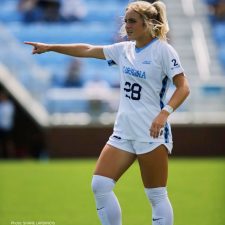Maggie Pierce pointing to UNC teammates on soccer field.