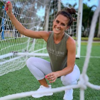 Laura Stark squating in front of soccer goal.